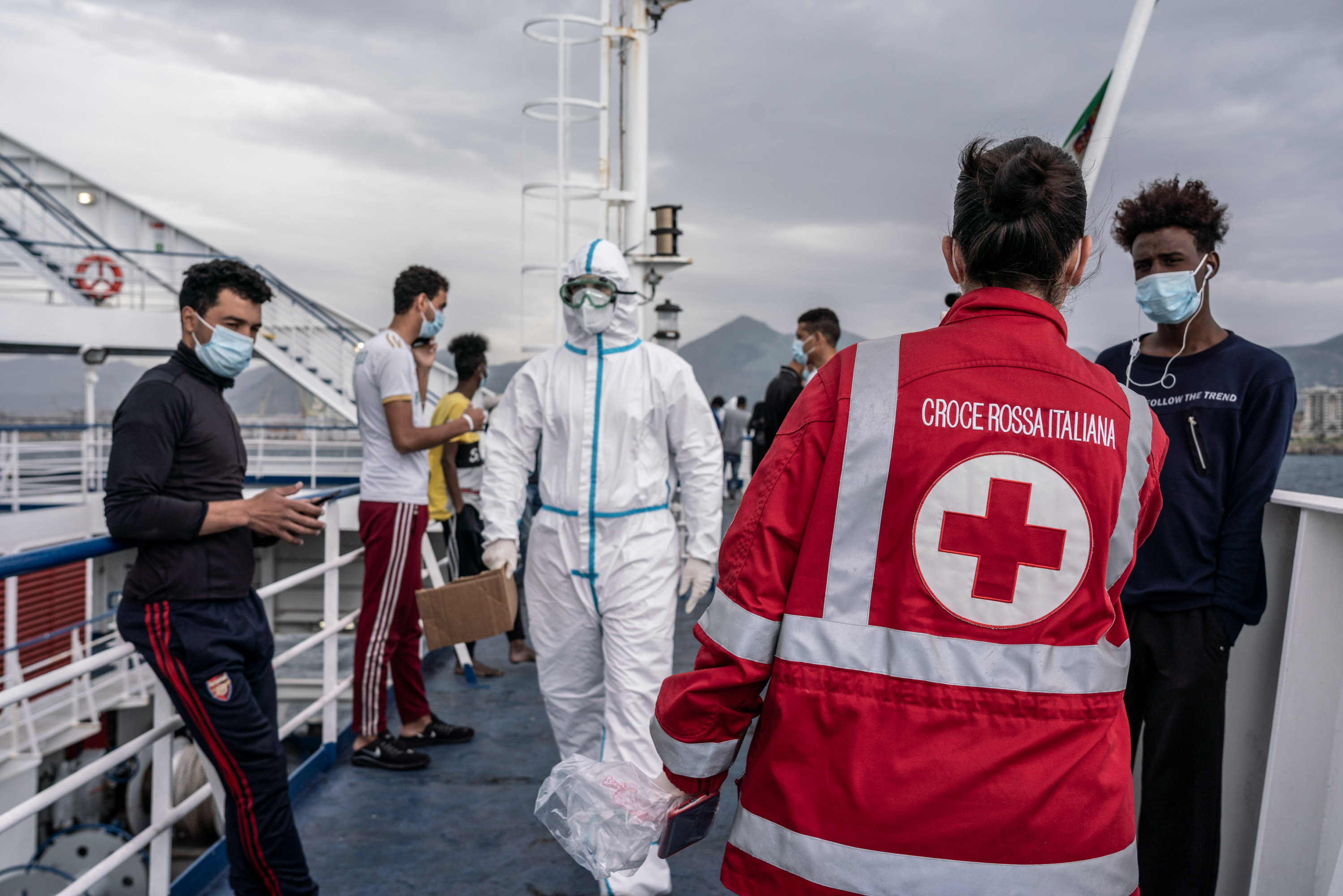 Un groupe de personnes debout sur un bateau avec des membres du personnel de la Croix-Rouge.