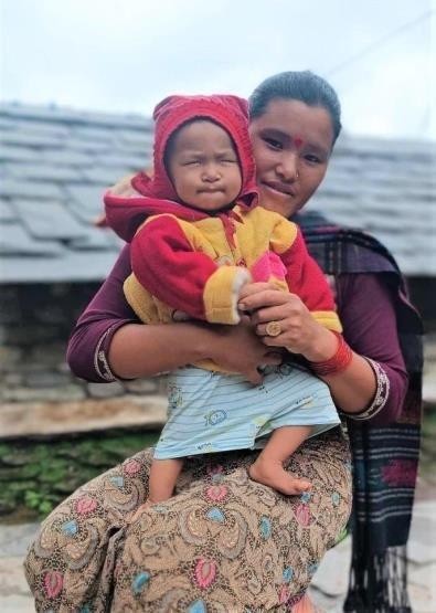 Une femme tient son bébé, démontrant le lien qui unit une mère et son enfant.