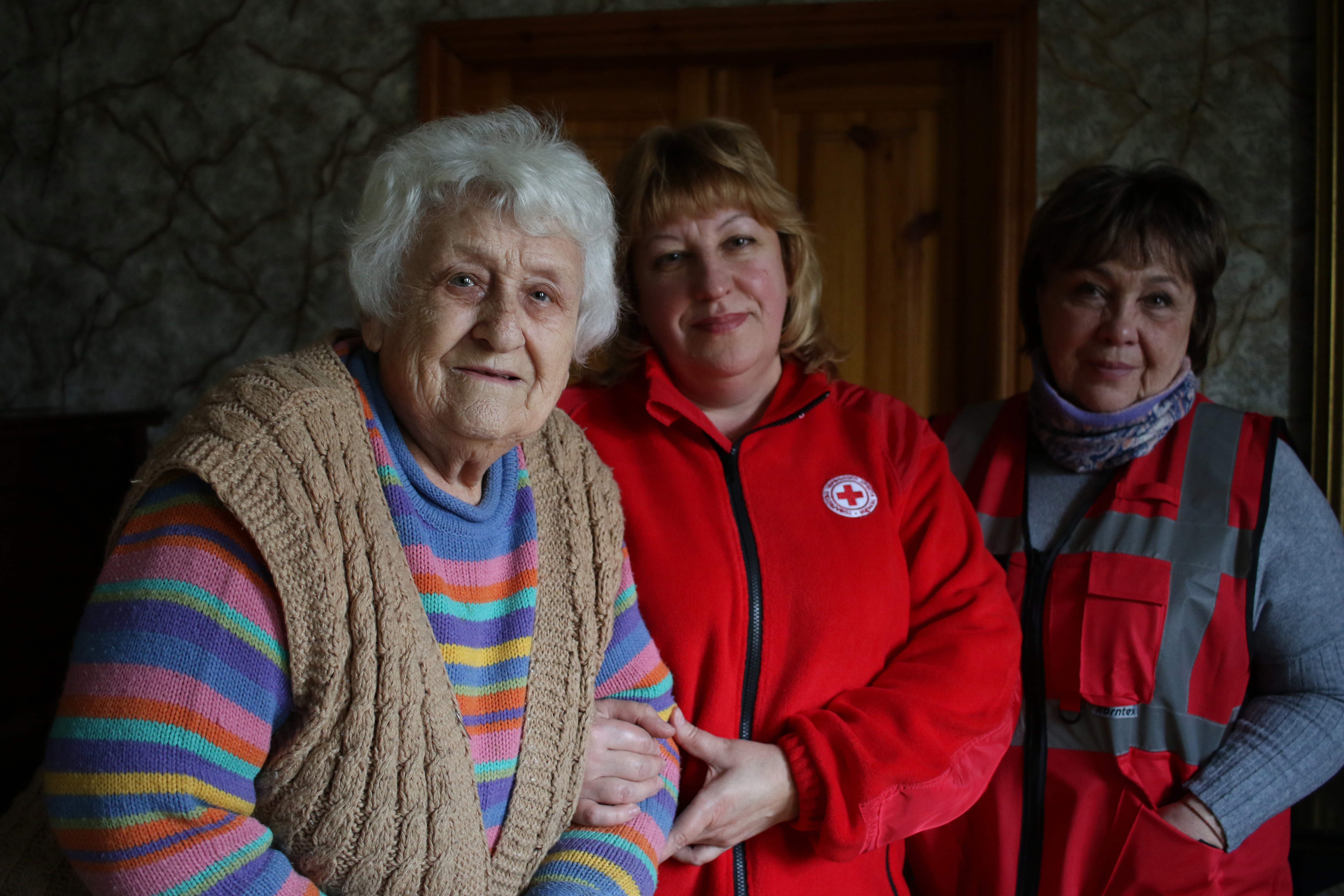 Un groupe de trois femmes se tiennent debout.